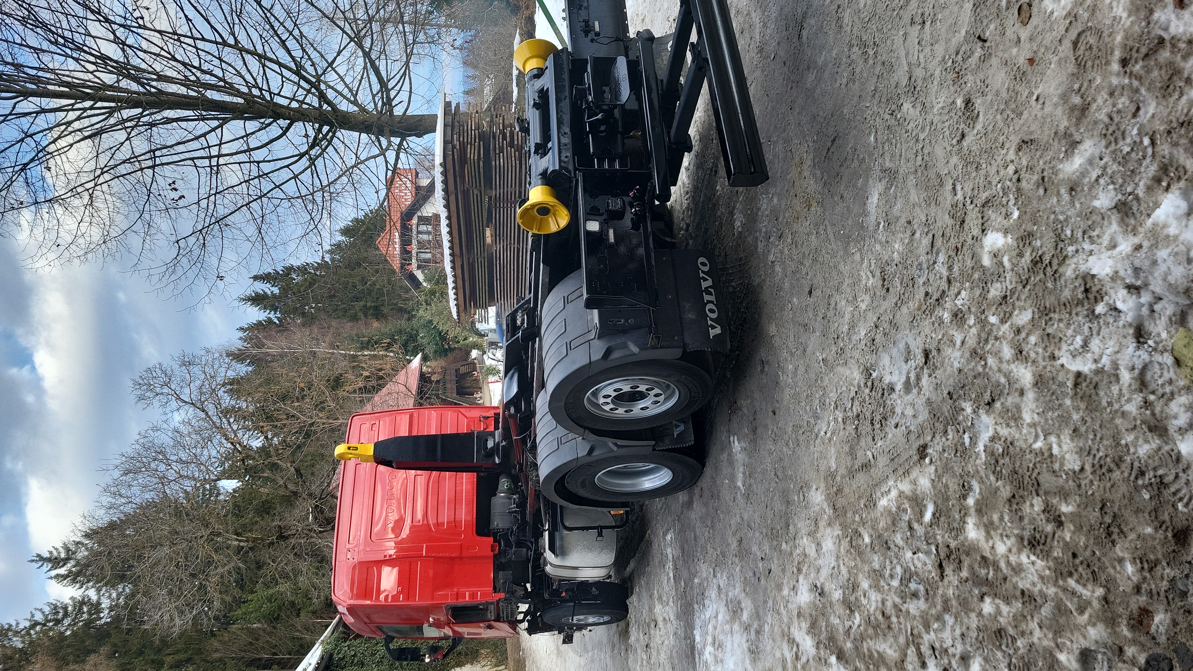 Prebarvan tovornjak Volvo s kavljem, pogled od zadaj