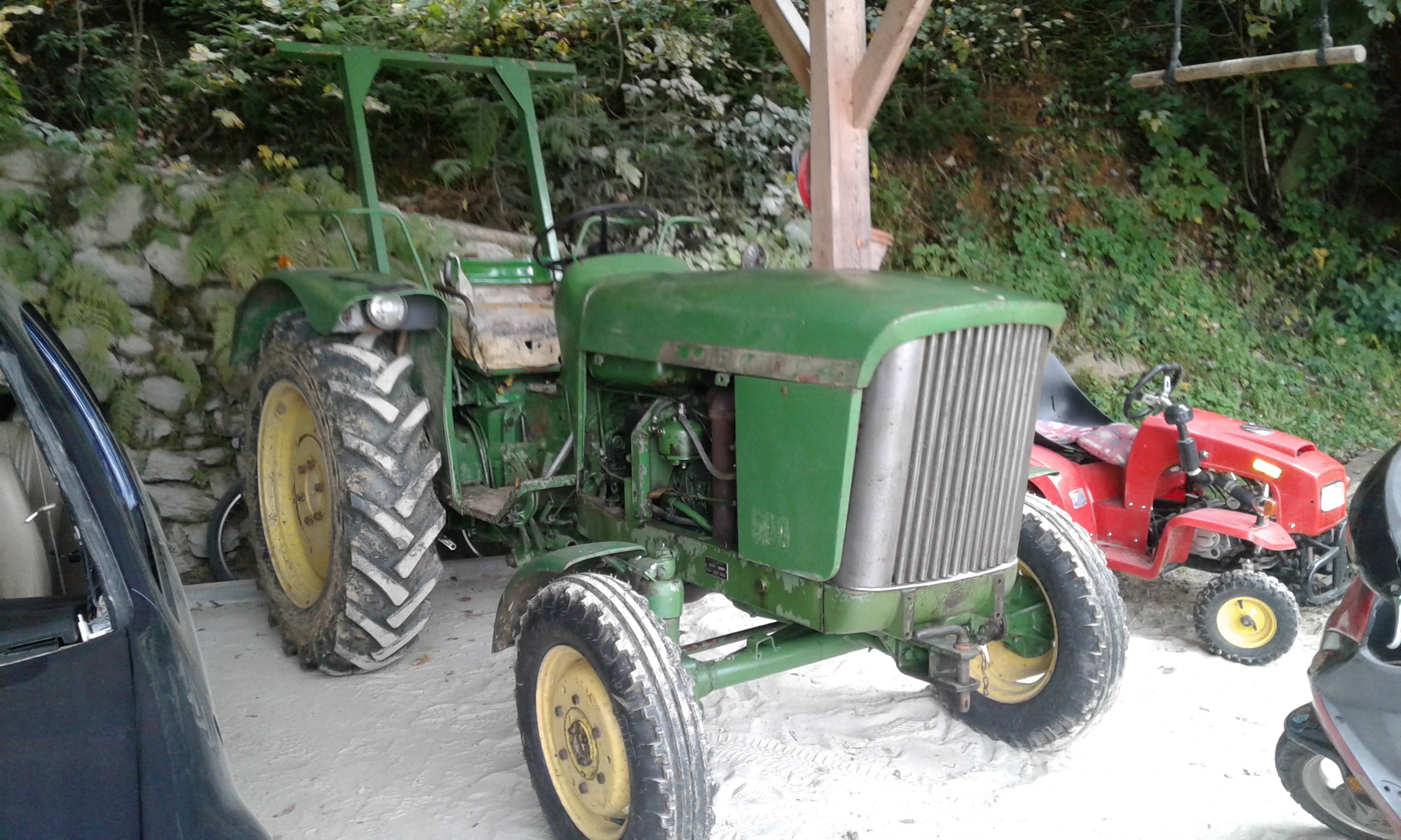 Star zelen traktor z zbledelo in odluščeno barvo pred obnovo